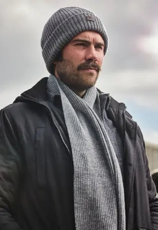 Man wearing Raging Bull  hat and a scarf with clouds in the backround.