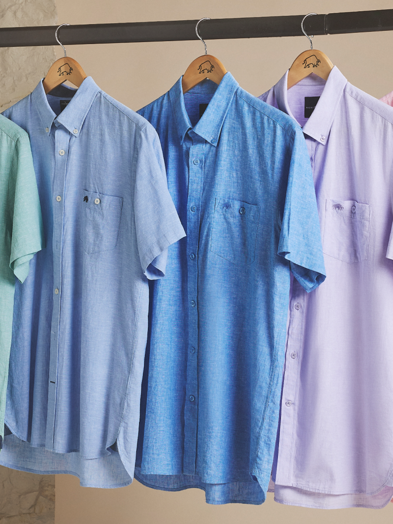 Summer shirts with short sleeves hanging on a rail.
