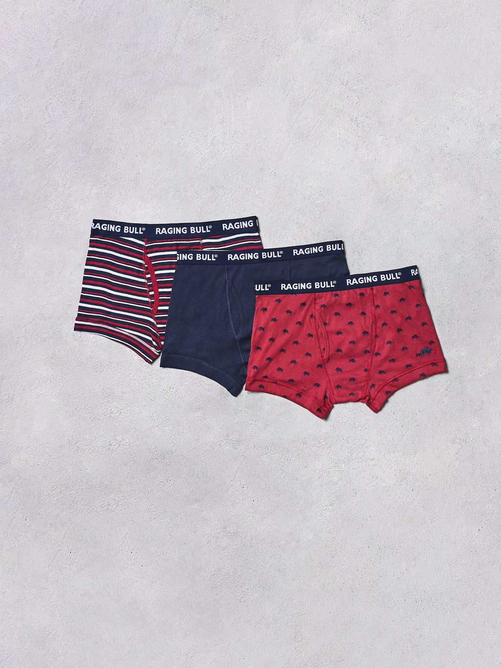 Three pairs of men's underwear with different patterns on a light gray background