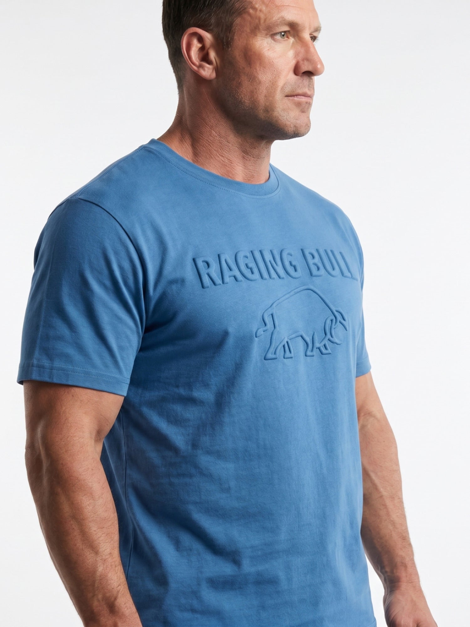 Man wearing a blue t-shirt with 'Raging Bull' logo on a white background