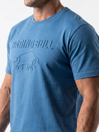 Man wearing a Raging Bull 3D emboss graphic t-shirt in denim, front. 