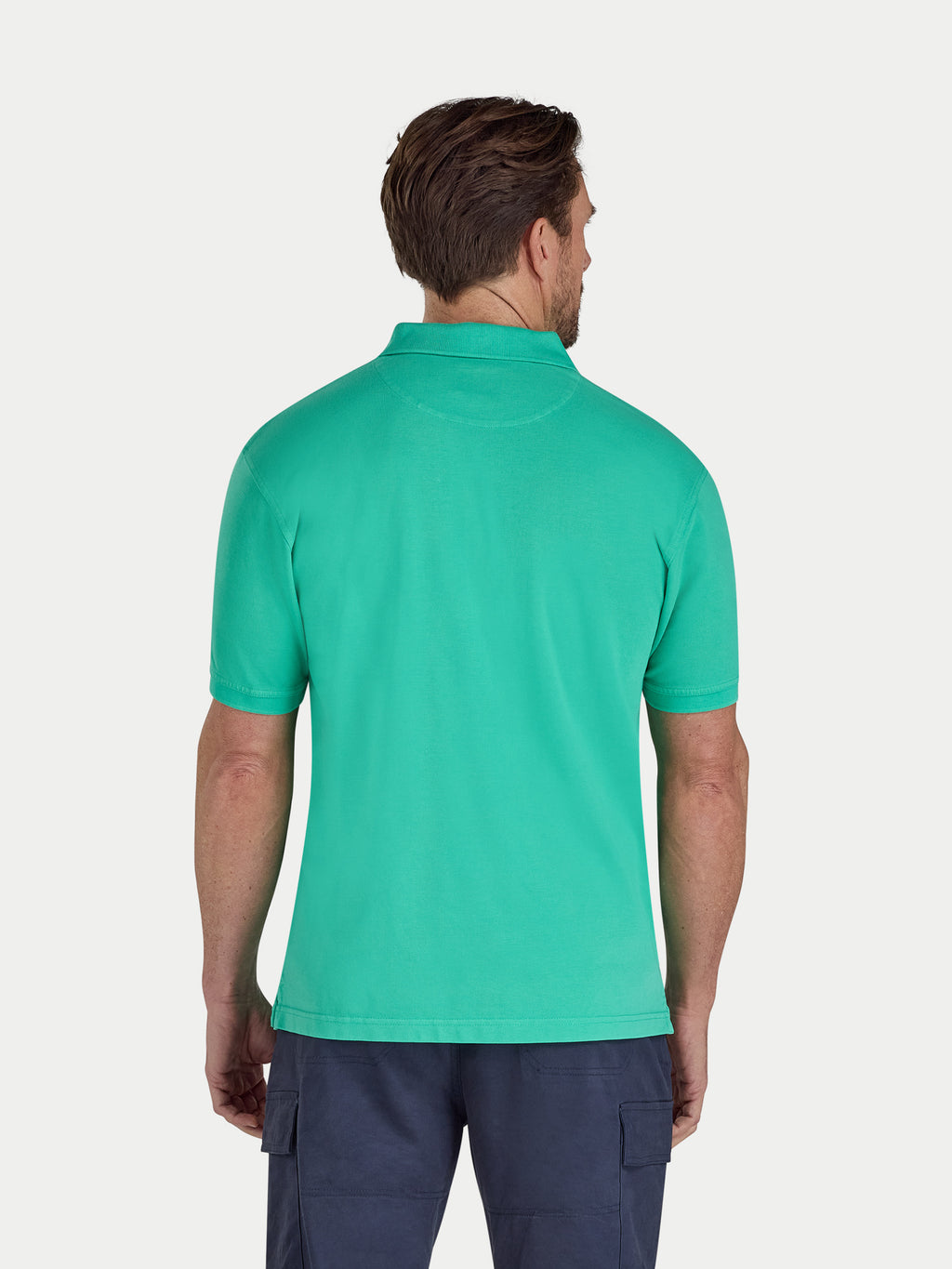 Man wearing a green polo shirt on a white background