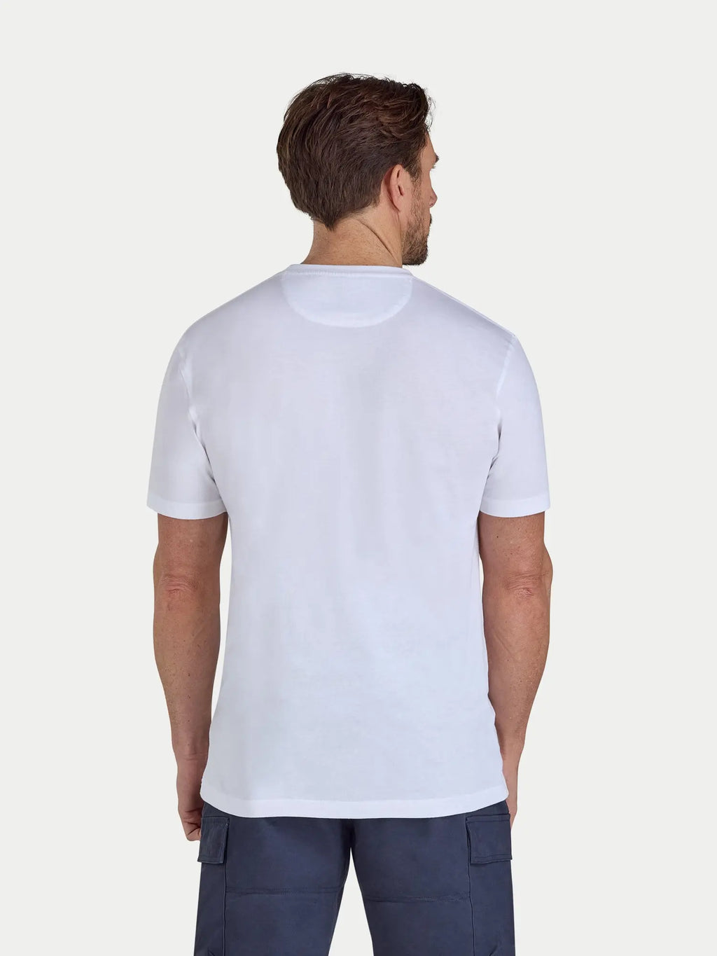 Man wearing a plain white t-shirt on a light gray background