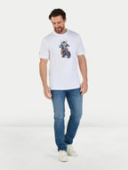 Man wearing a white t-shirt with a graphic design and blue jeans on a light gray background