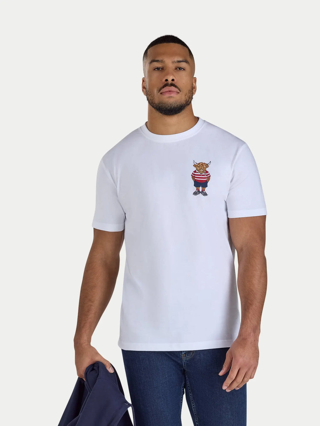Man wearing a white t-shirt with a small graphic on a plain background