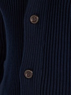 Close-up of a navy blue cardigan with two buttons.