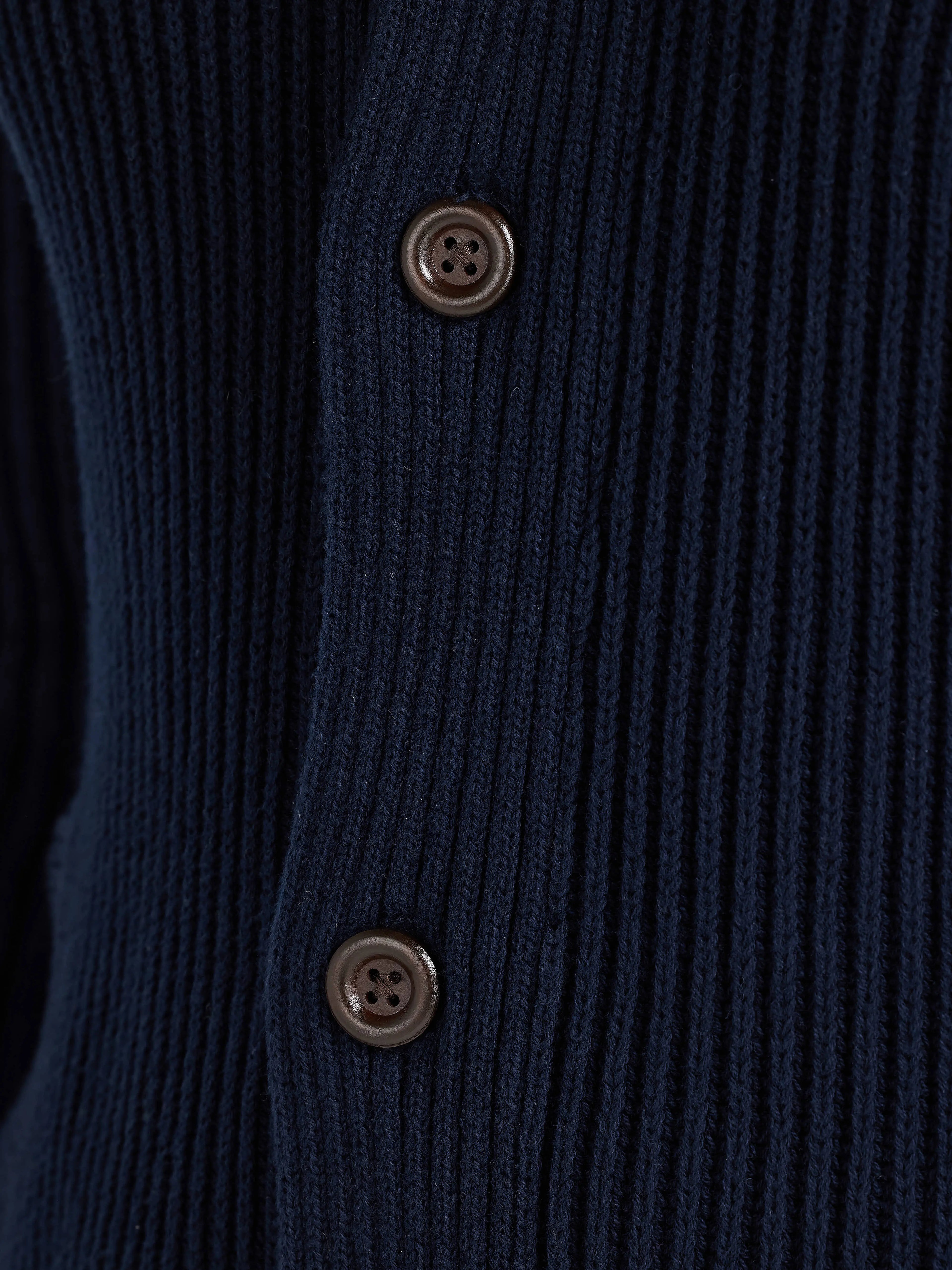 Close-up of a navy blue cardigan with two buttons.