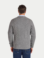 Man wearing a gray cable knit sweater on a white background