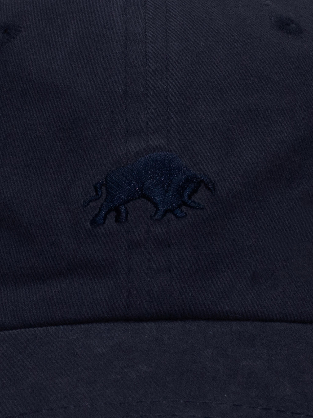 Close-up of navy blue cap with a small Raging Bull logo.