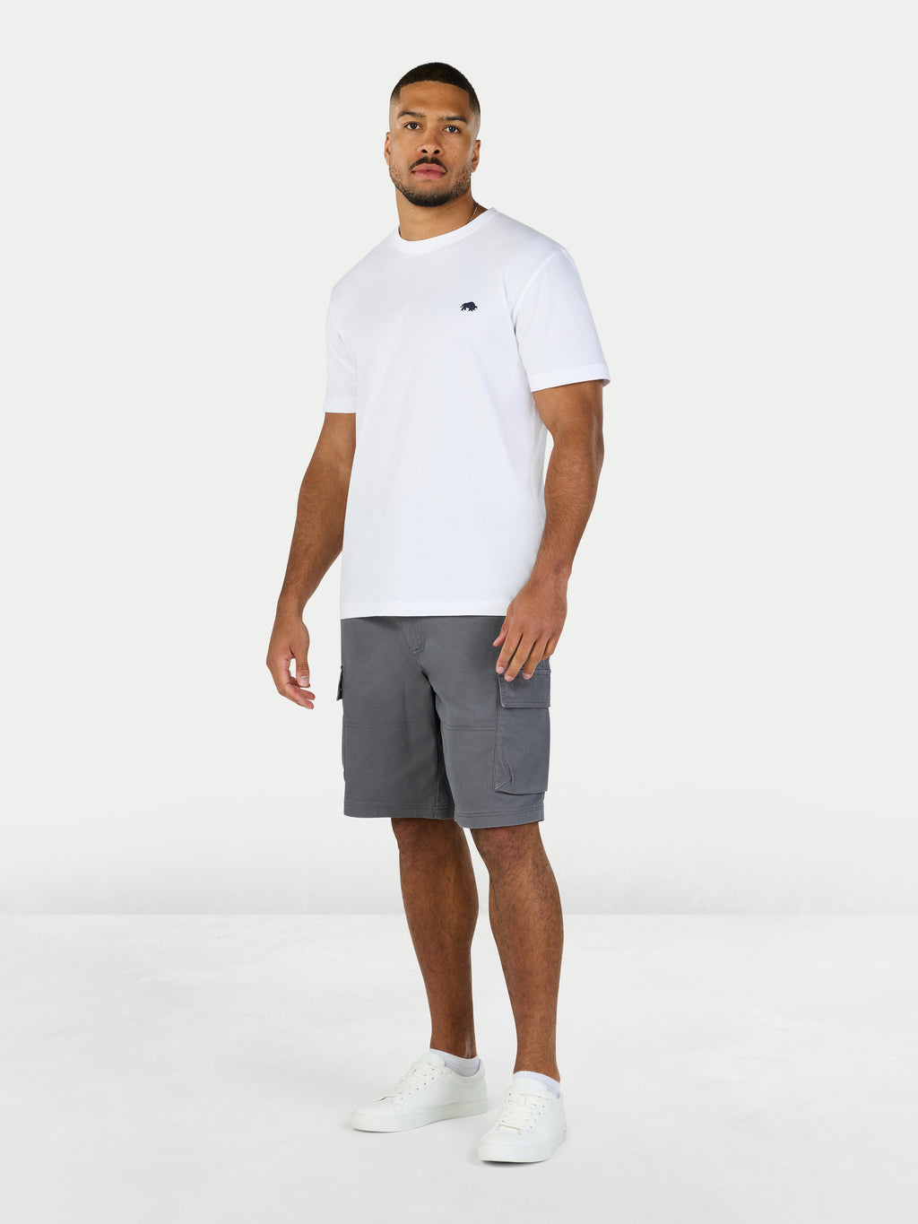 Man wearing a white t-shirt and gray shorts on a white background