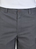 Close-up of gray shorts with a button and waistband detail.
