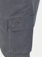 Close-up of a pocket on gray shorts with a logo, on a white background