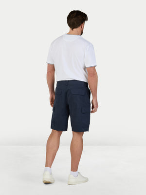 Man wearing navy cargo shorts and a white t-shirt on a white background