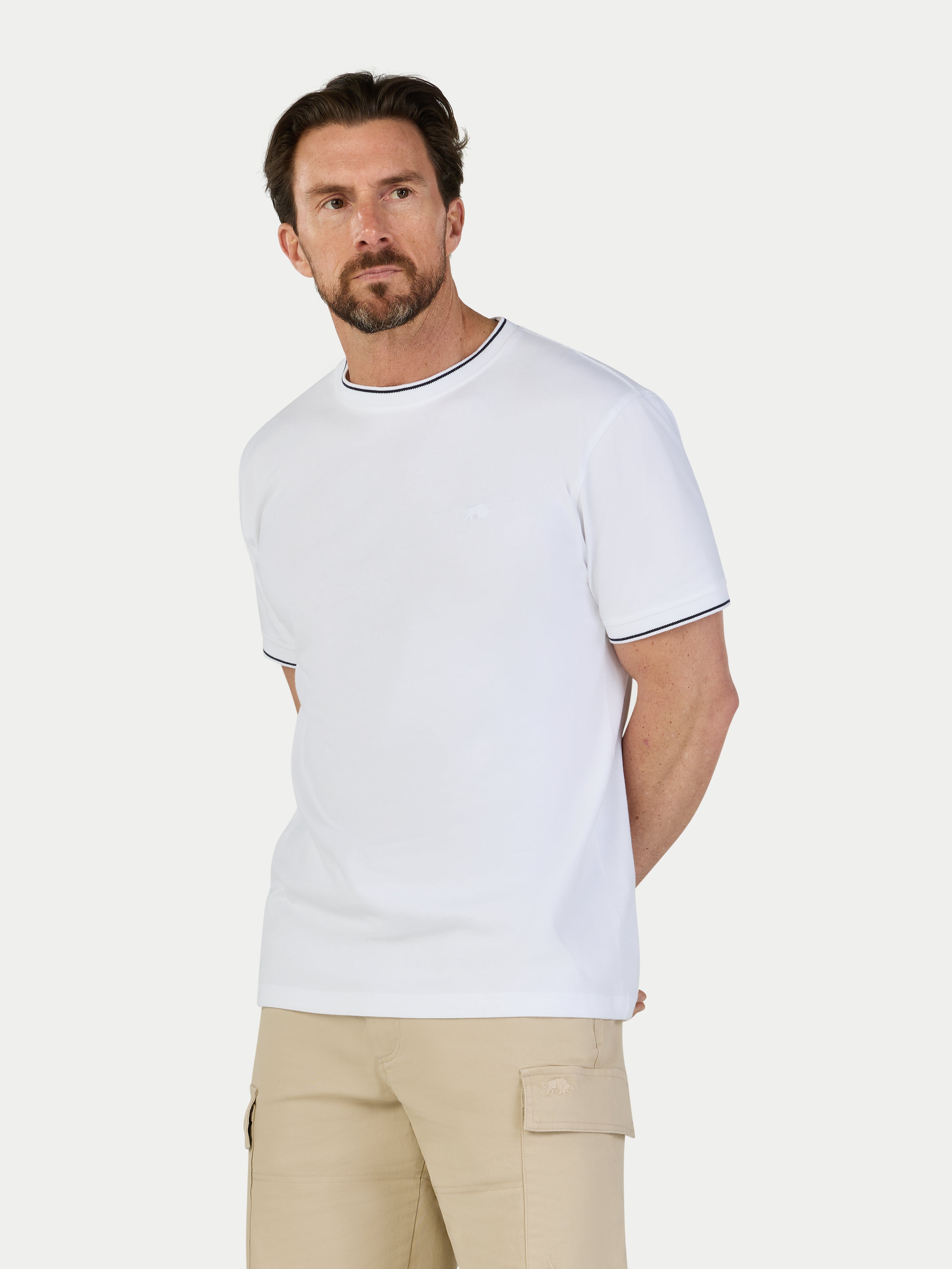 Man wearing a white t-shirt with black trim on a white background