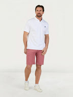Man wearing Raging Bull Classic Chino Shorts in Berry and Classic Organic Polo shirt in white. 