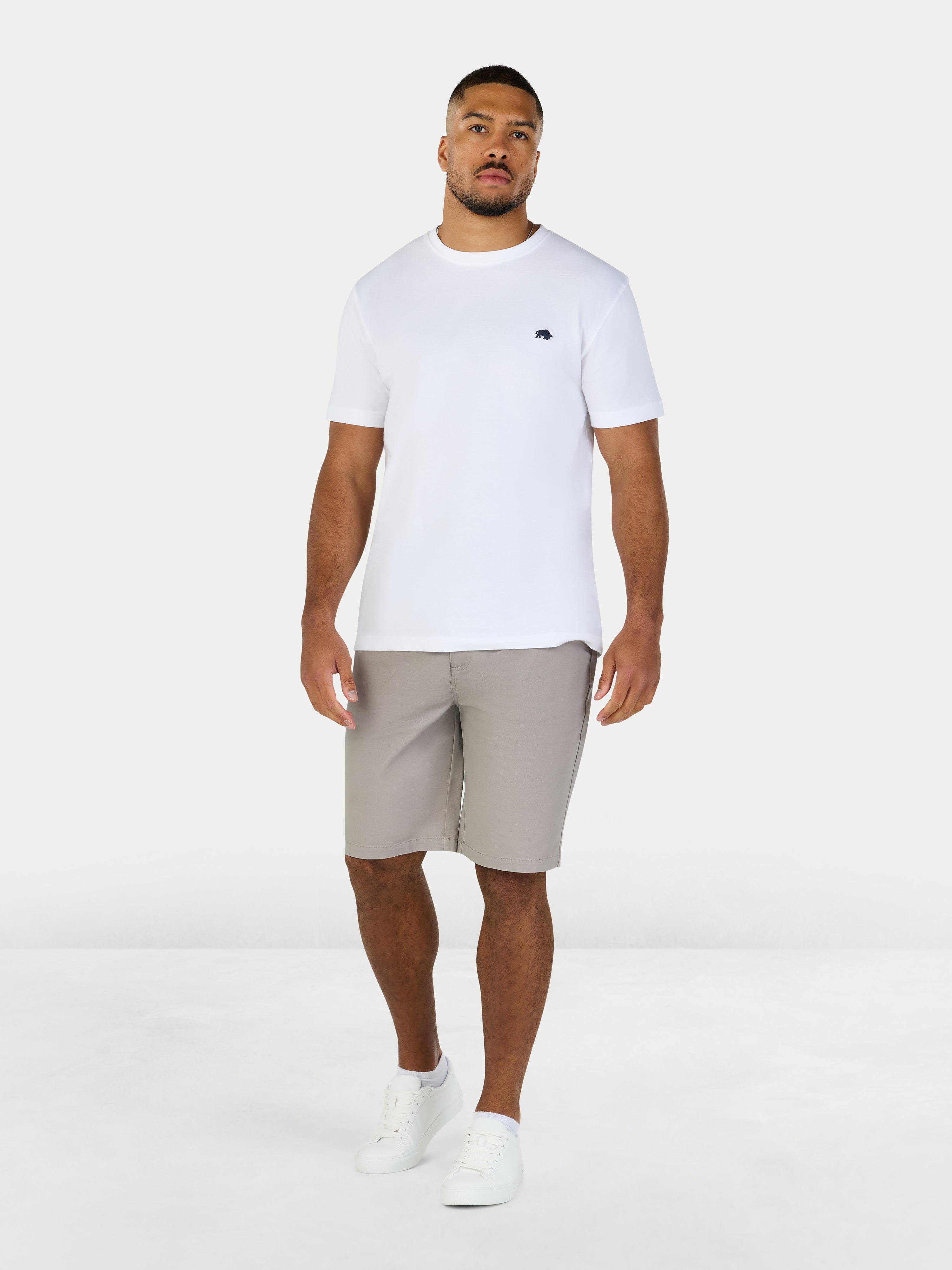 Man wearing a white t-shirt and gray shorts on a white background