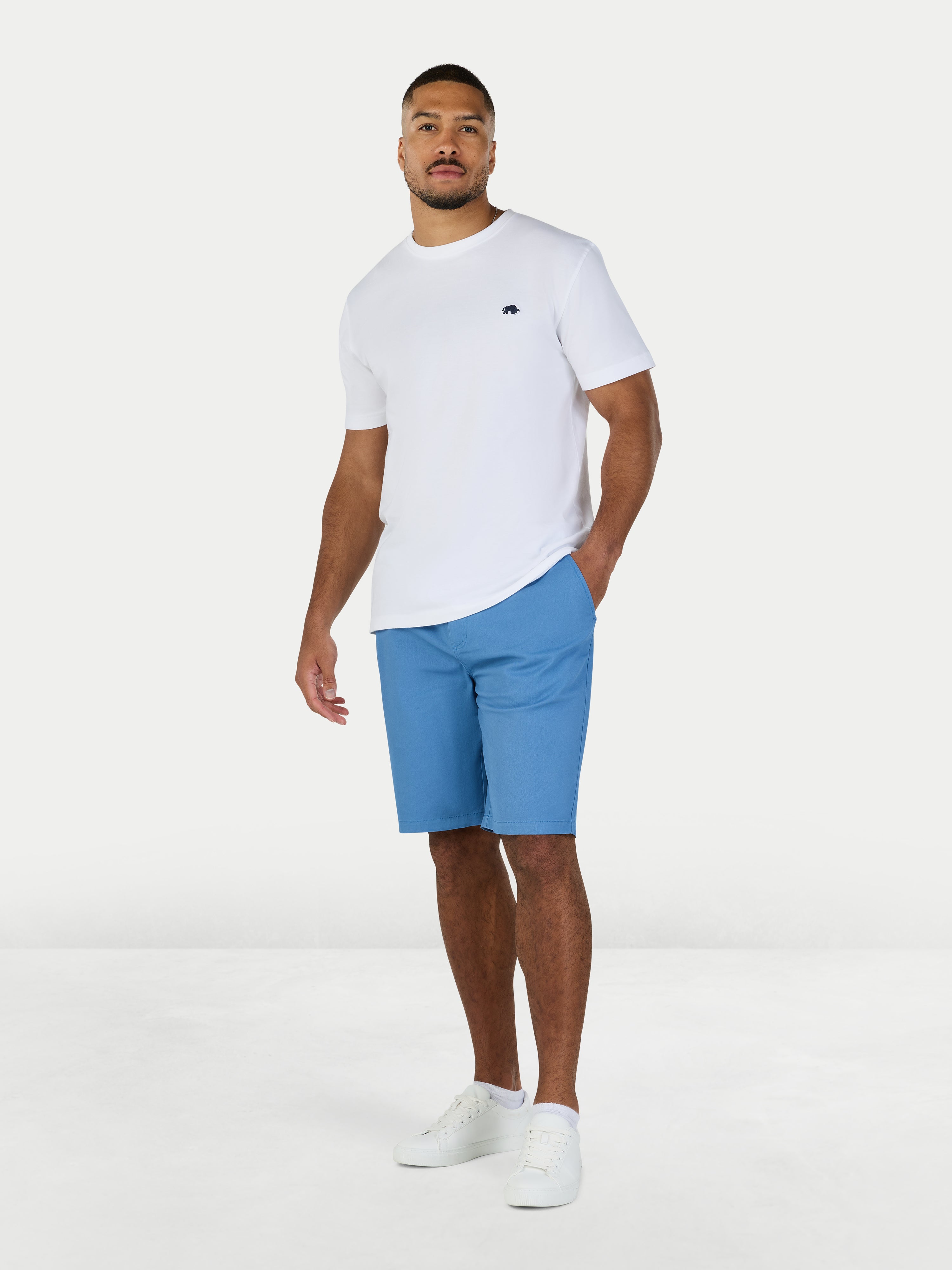 Man wearing a white t-shirt and blue shorts on a white background