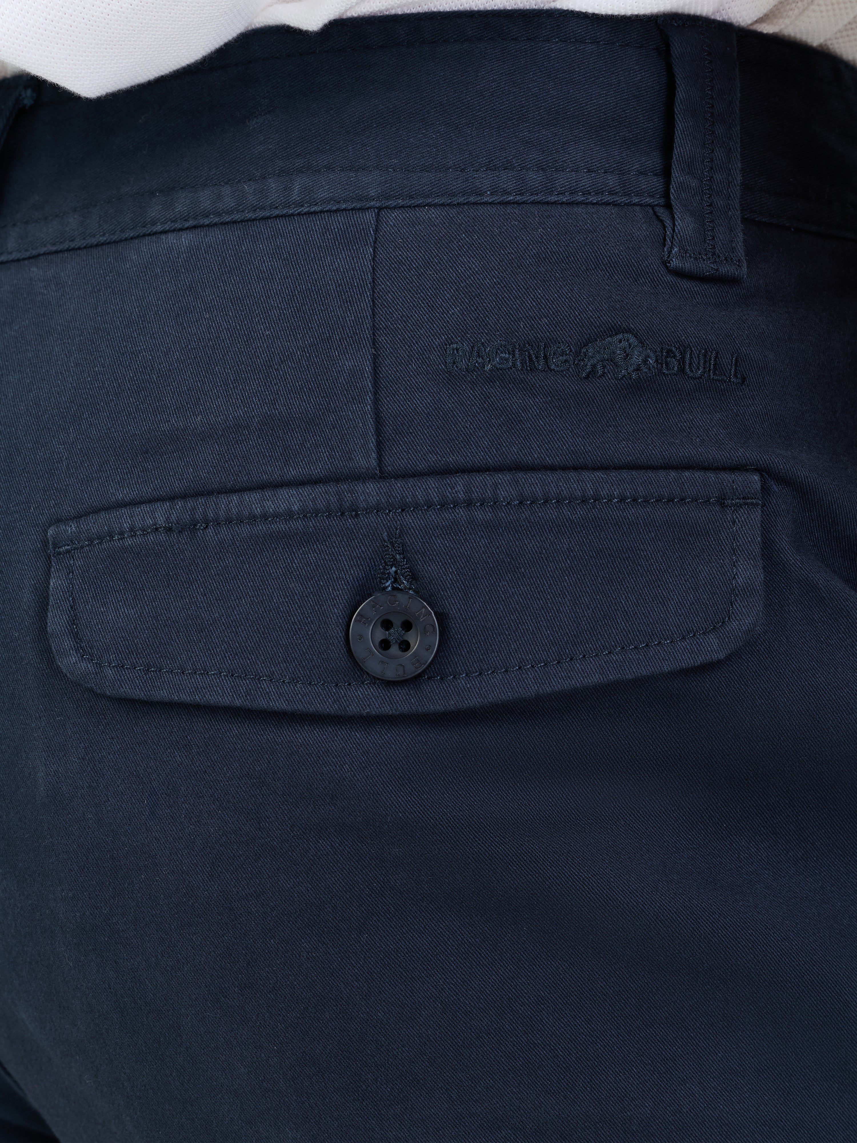 Navy blue pants with a button and brand logo on the pocket.