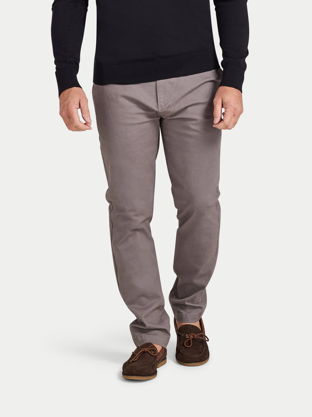 Person wearing gray pants and brown shoes on a white background