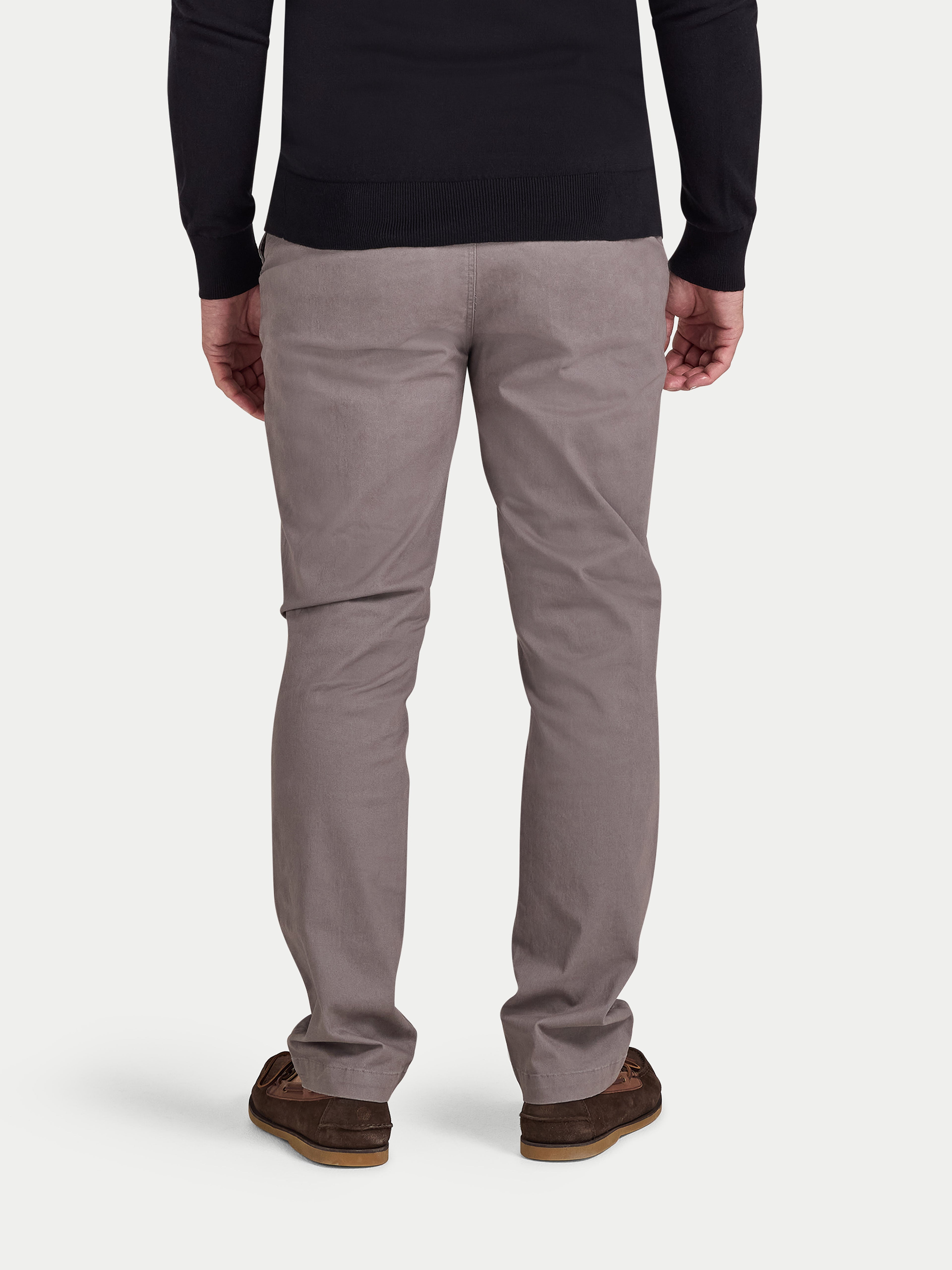 Person wearing gray pants and a black top on a white background