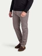 Person wearing gray pants and a black sweater on a white background