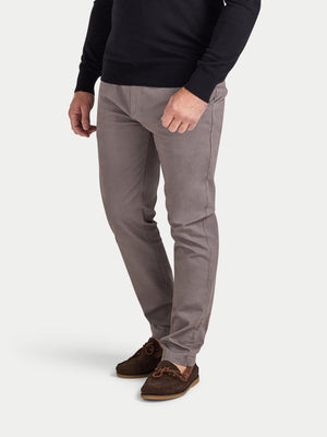 Person wearing gray pants and a black sweater on a white background