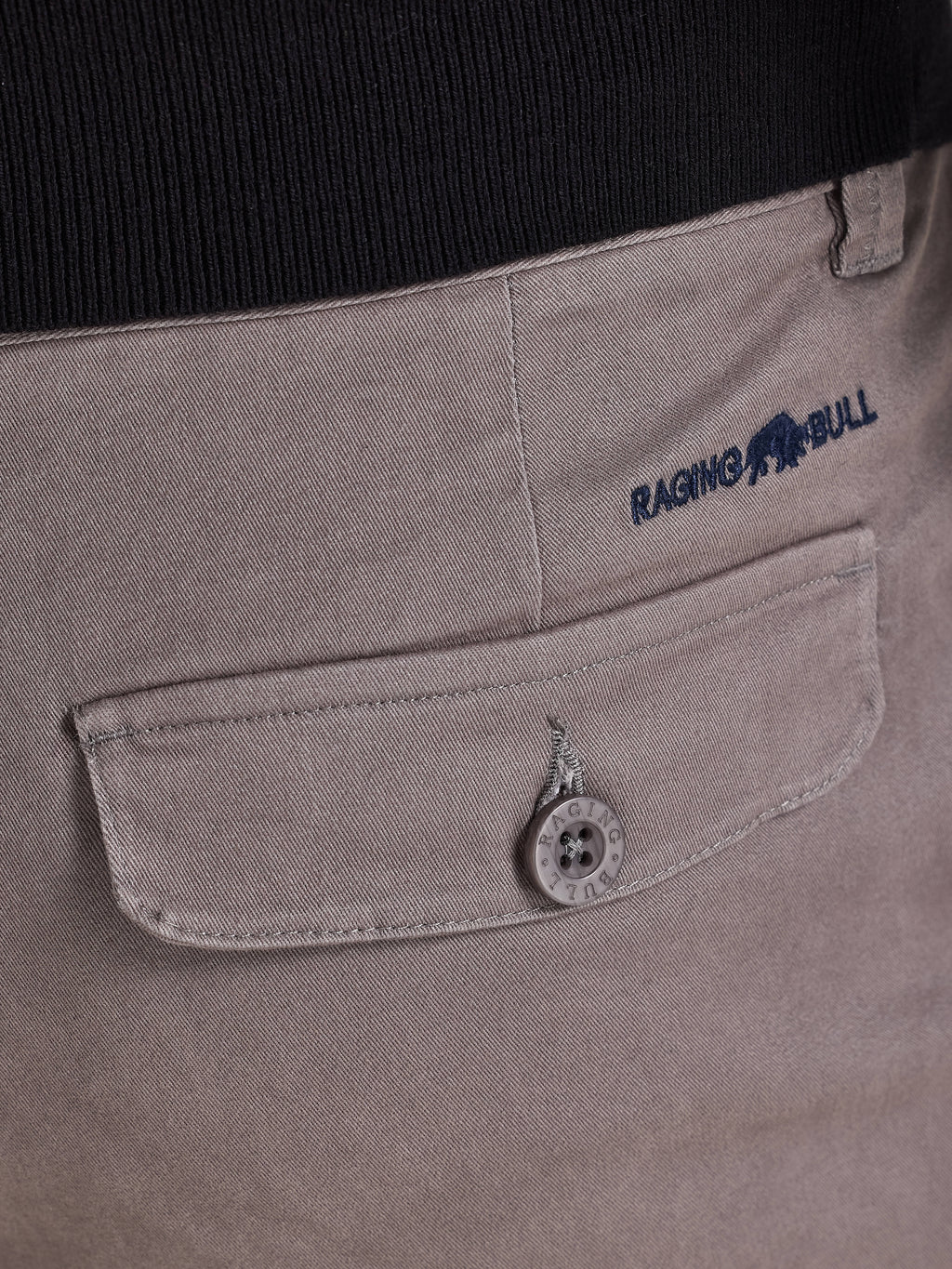 Close-up of a pocket on a garment with 'Raging Bull' branding.