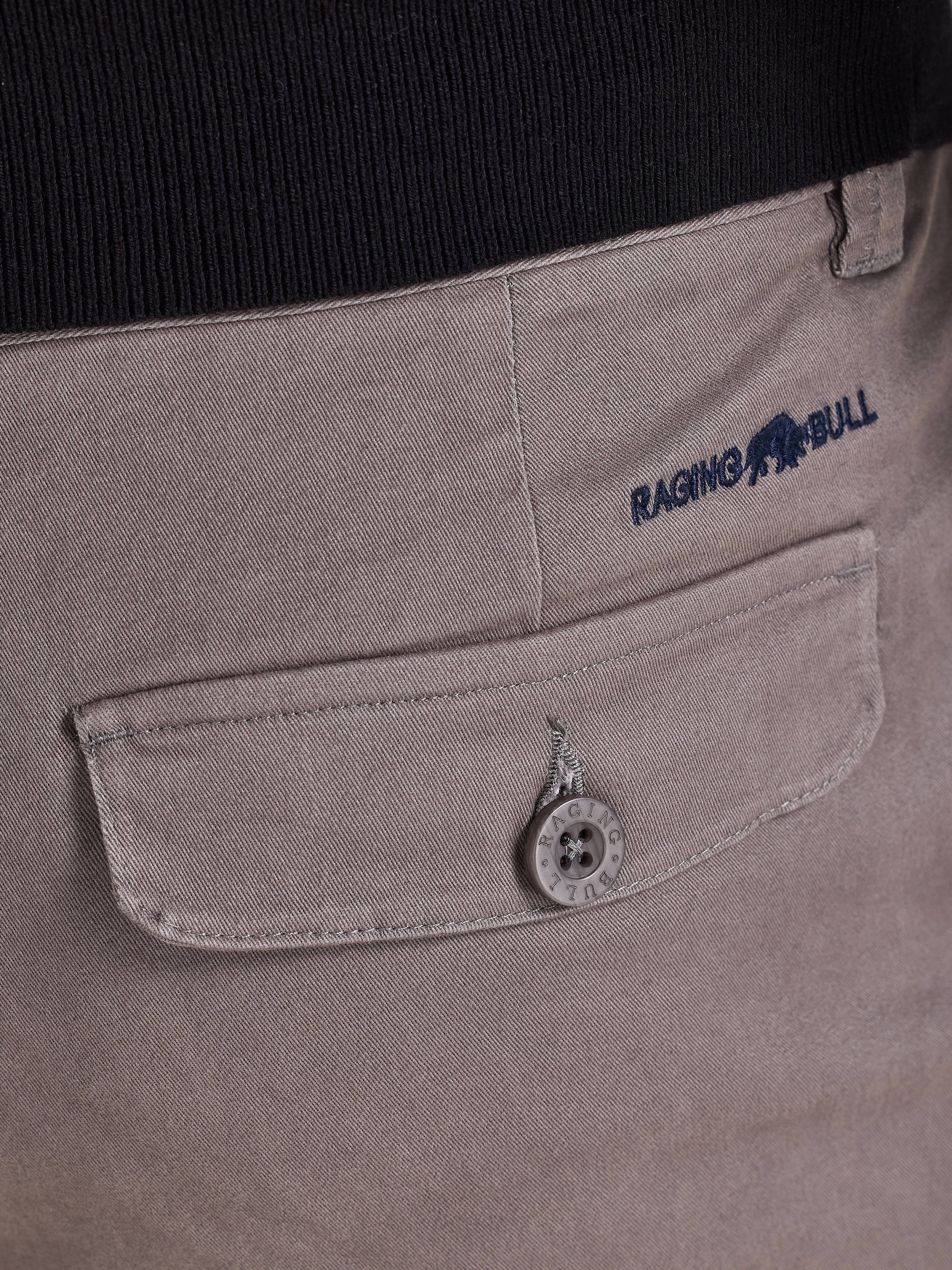 Close-up of a pocket on a garment with 'Raging Bull' branding.
