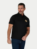 Man wearing a black polo shirt with a logo on a white background