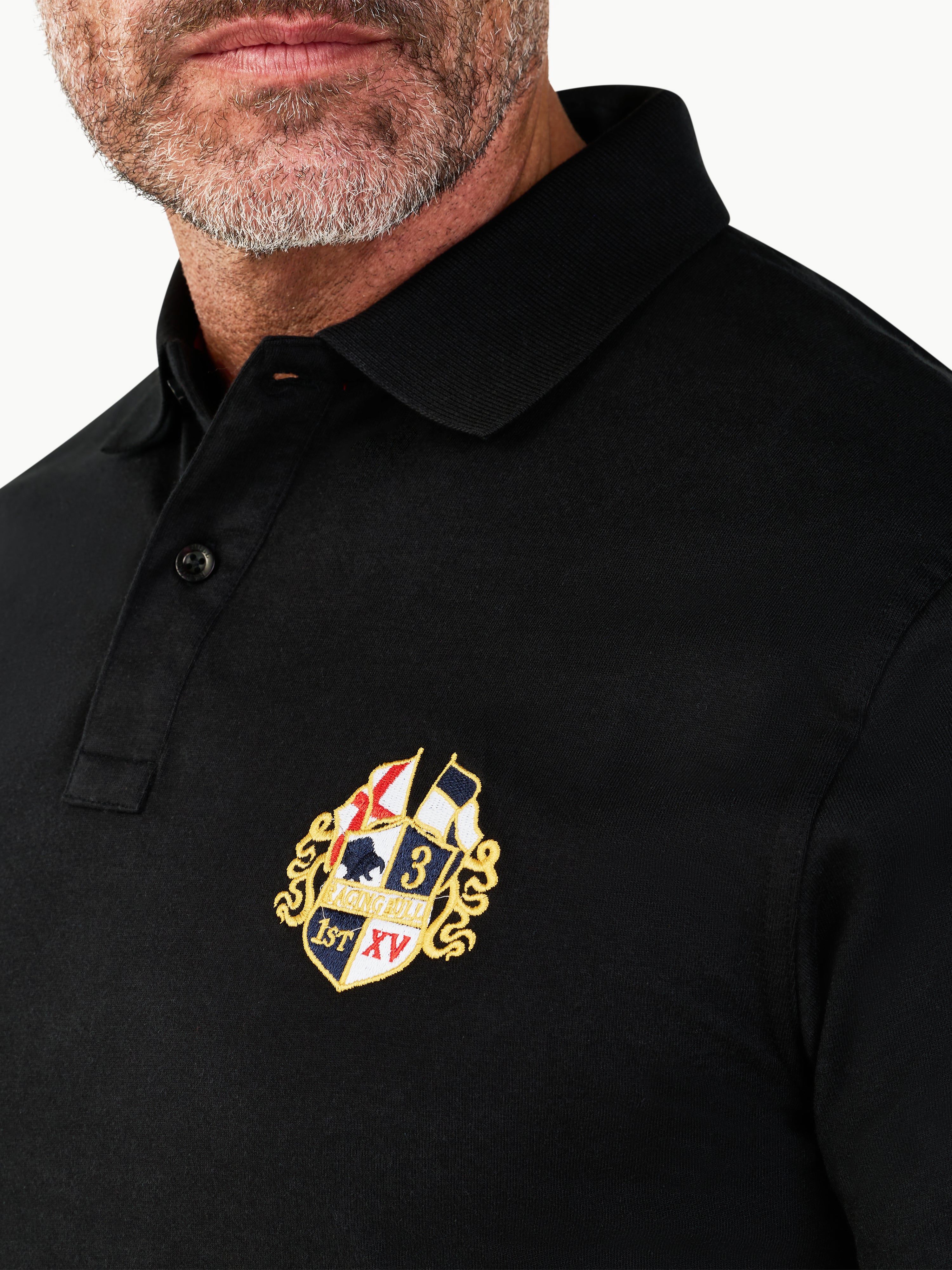 Black polo shirt with a embroidered logo on a white background