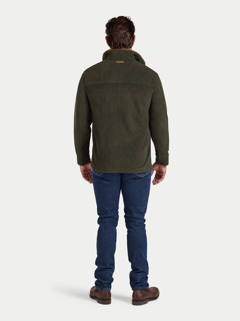 Man wearing a green jacket and blue jeans on a white background