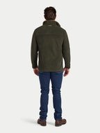 Man wearing a green jacket and blue jeans on a white background