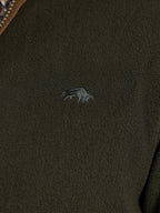 Close-up of a dark green fleece jacket with a Raging Bull logo on the chest.