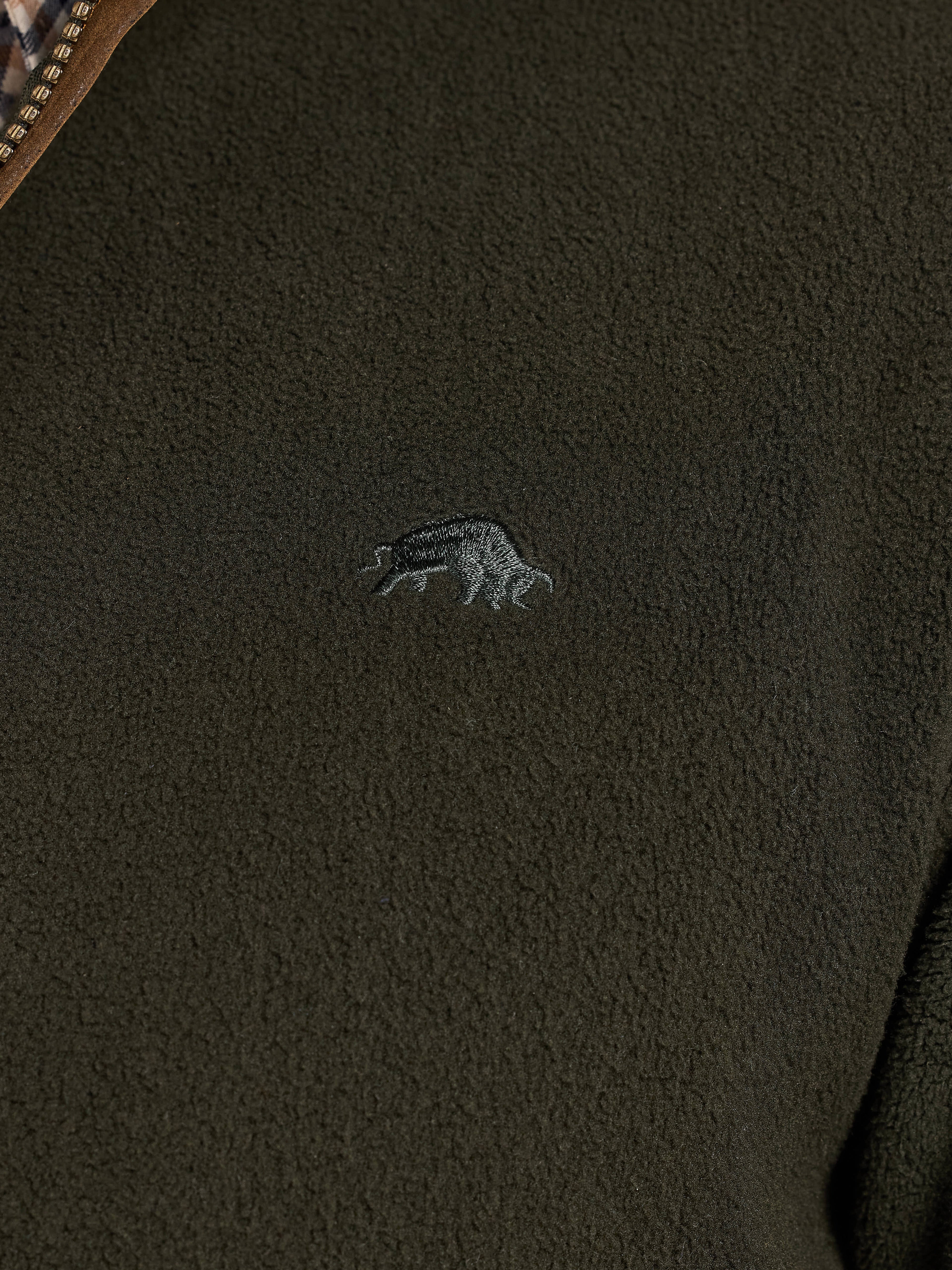 Close-up of a dark green fleece jacket with a Raging Bull logo on the chest.