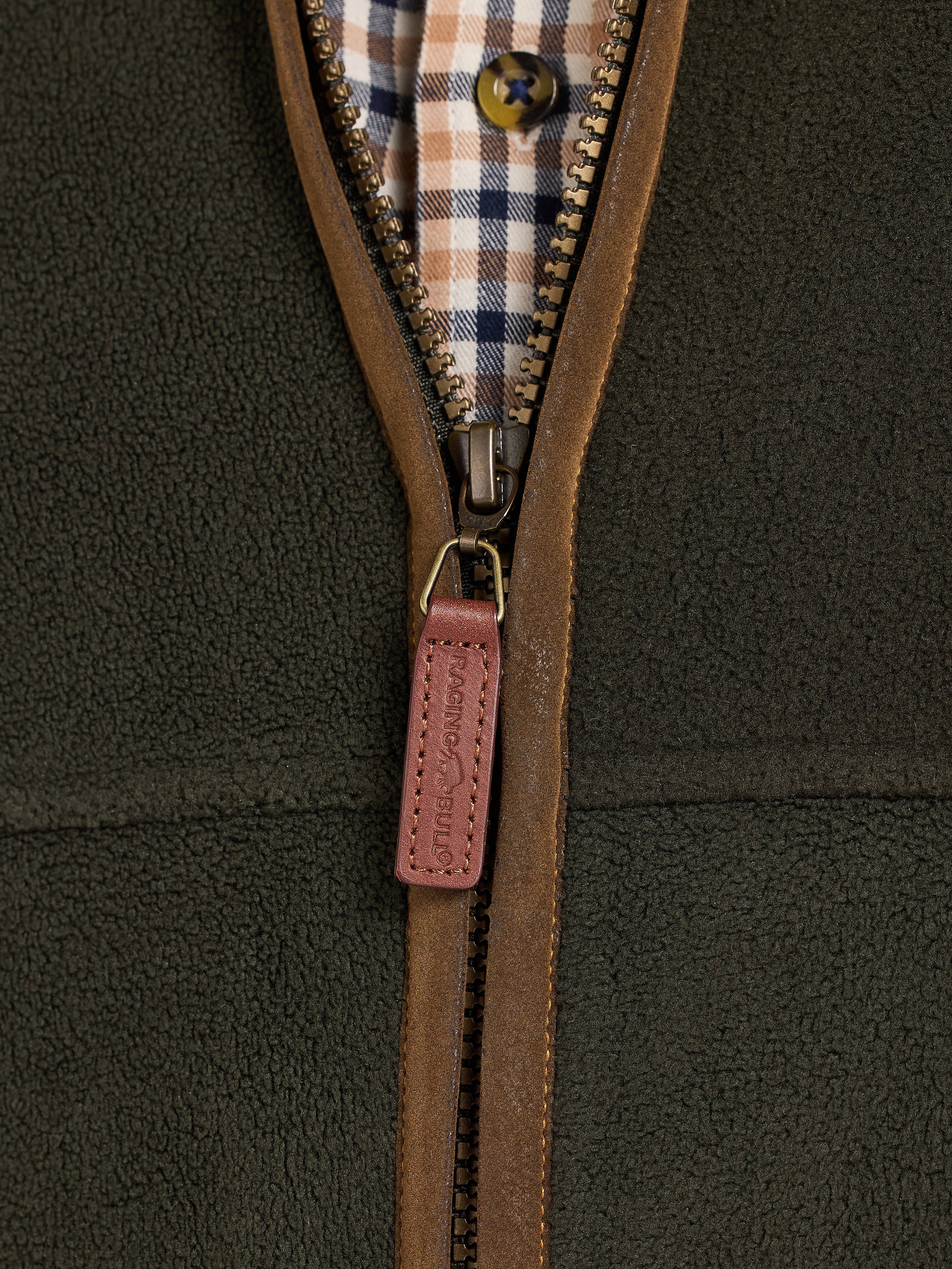 Close-up of a brown zipper on a green fleece jacket