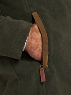 Close-up of a person wearing a dark green fleece jacket with a brown leather strap.