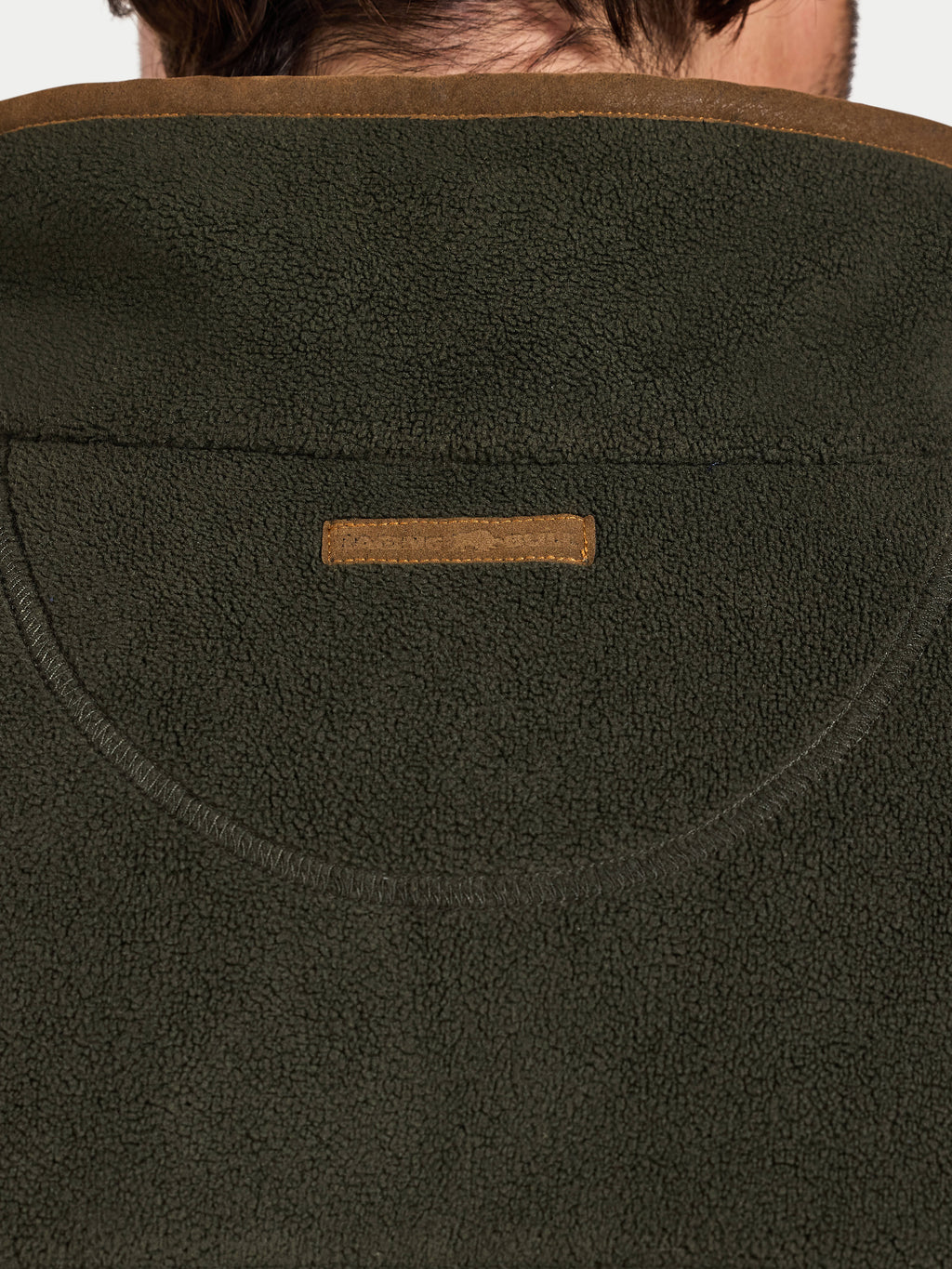 Close-up of a green fleece jacket with a brand logo on the chest.