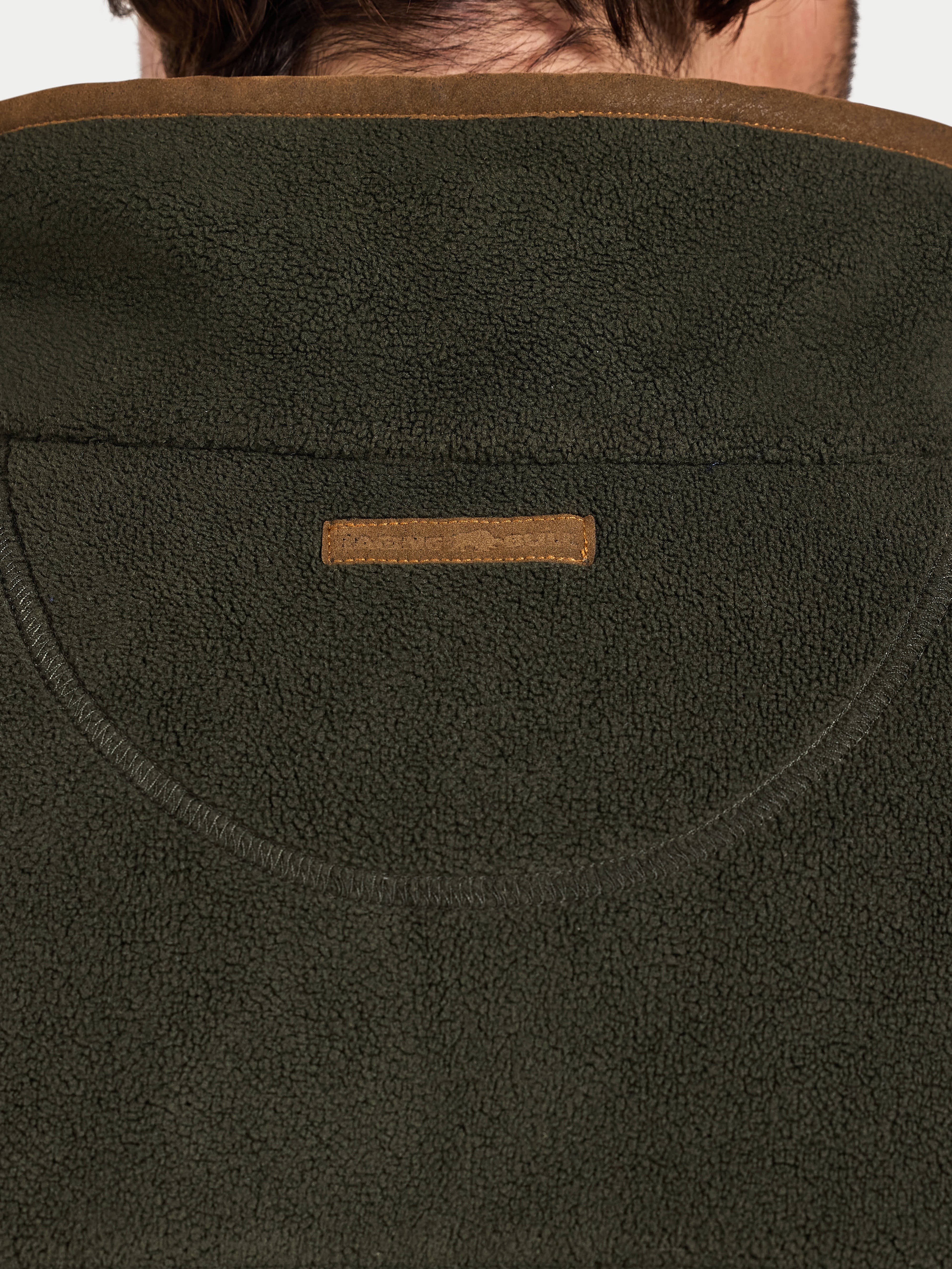 Close-up of a green fleece jacket with a brand logo on the chest.
