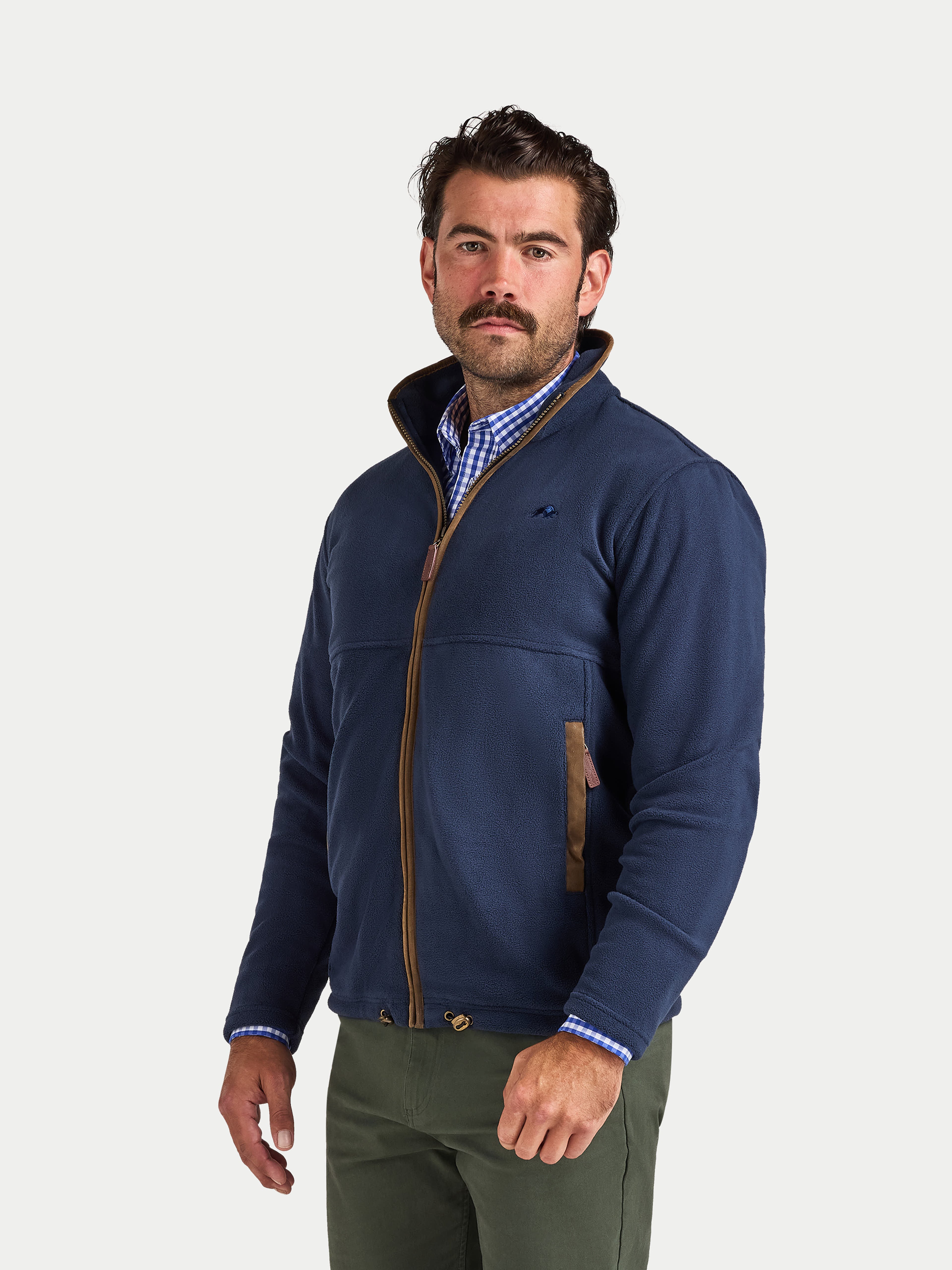 Man wearing a navy jacket with a plaid shirt underneath on a white background