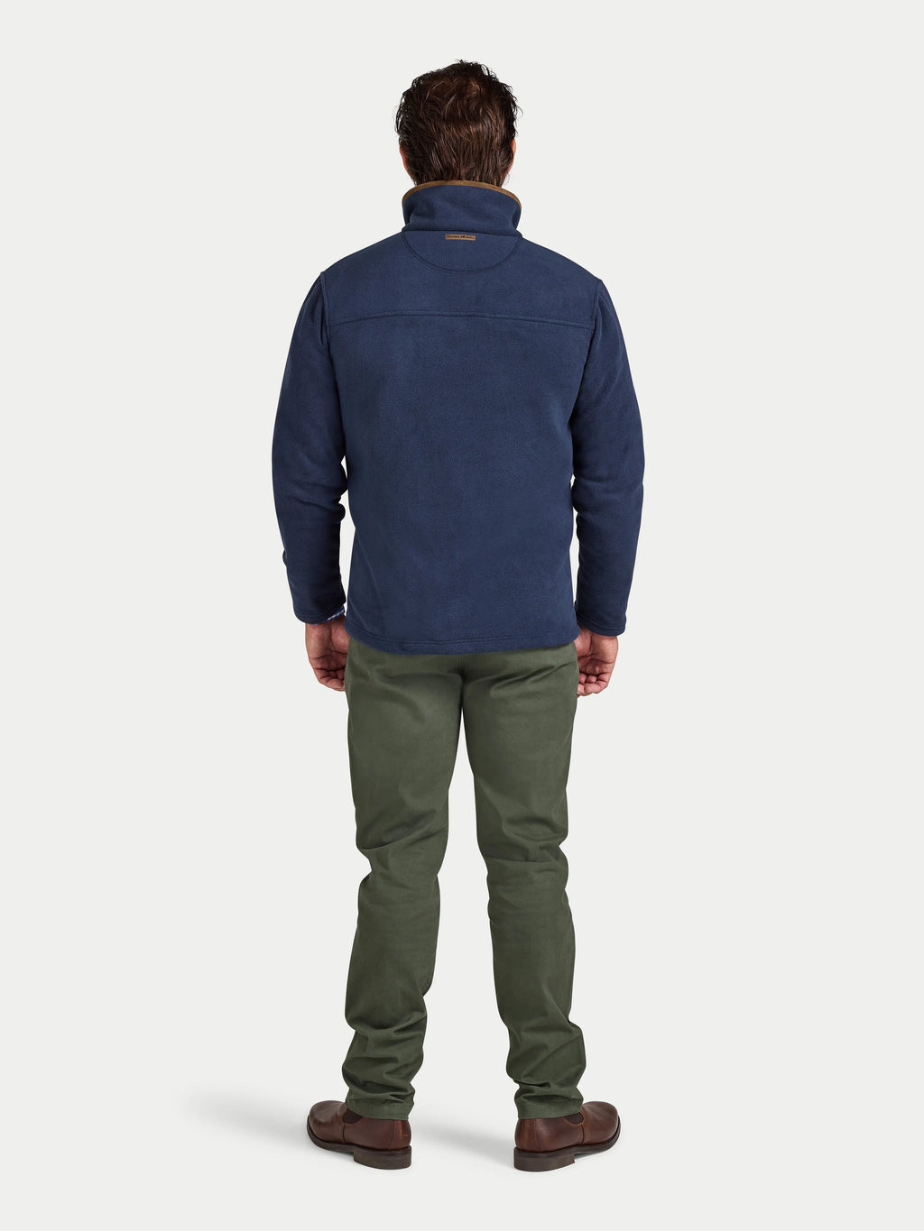 Man wearing a blue jacket and green pants on a white background