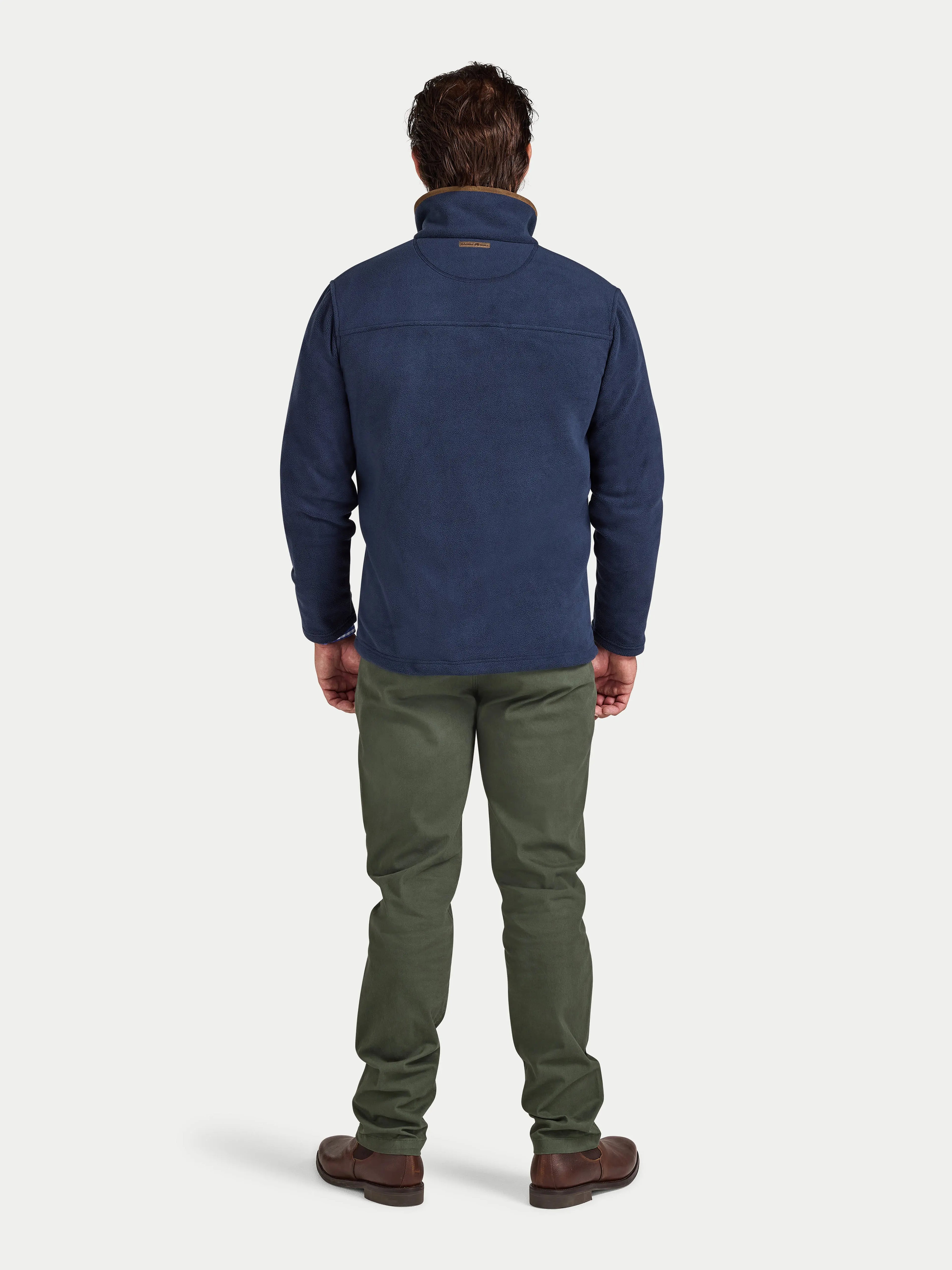 Man wearing a blue jacket and green pants on a white background