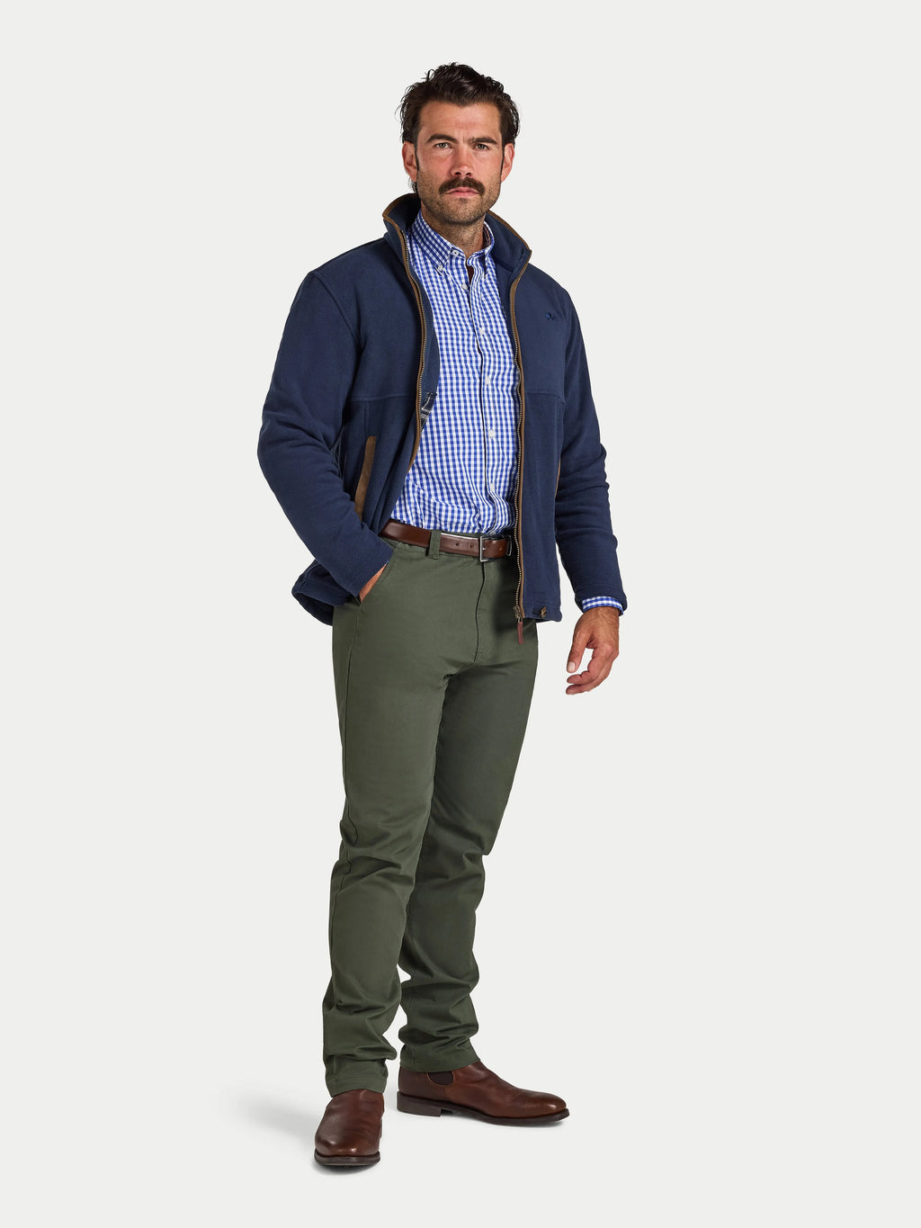 Man wearing a navy jacket, checkered shirt, and green pants on a white background