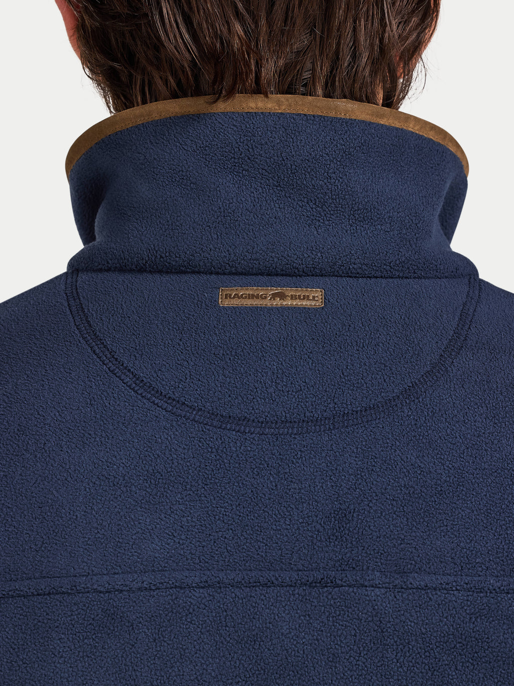 Navy blue jacket with brown collar and 'Raging Bull' logo on a white background
