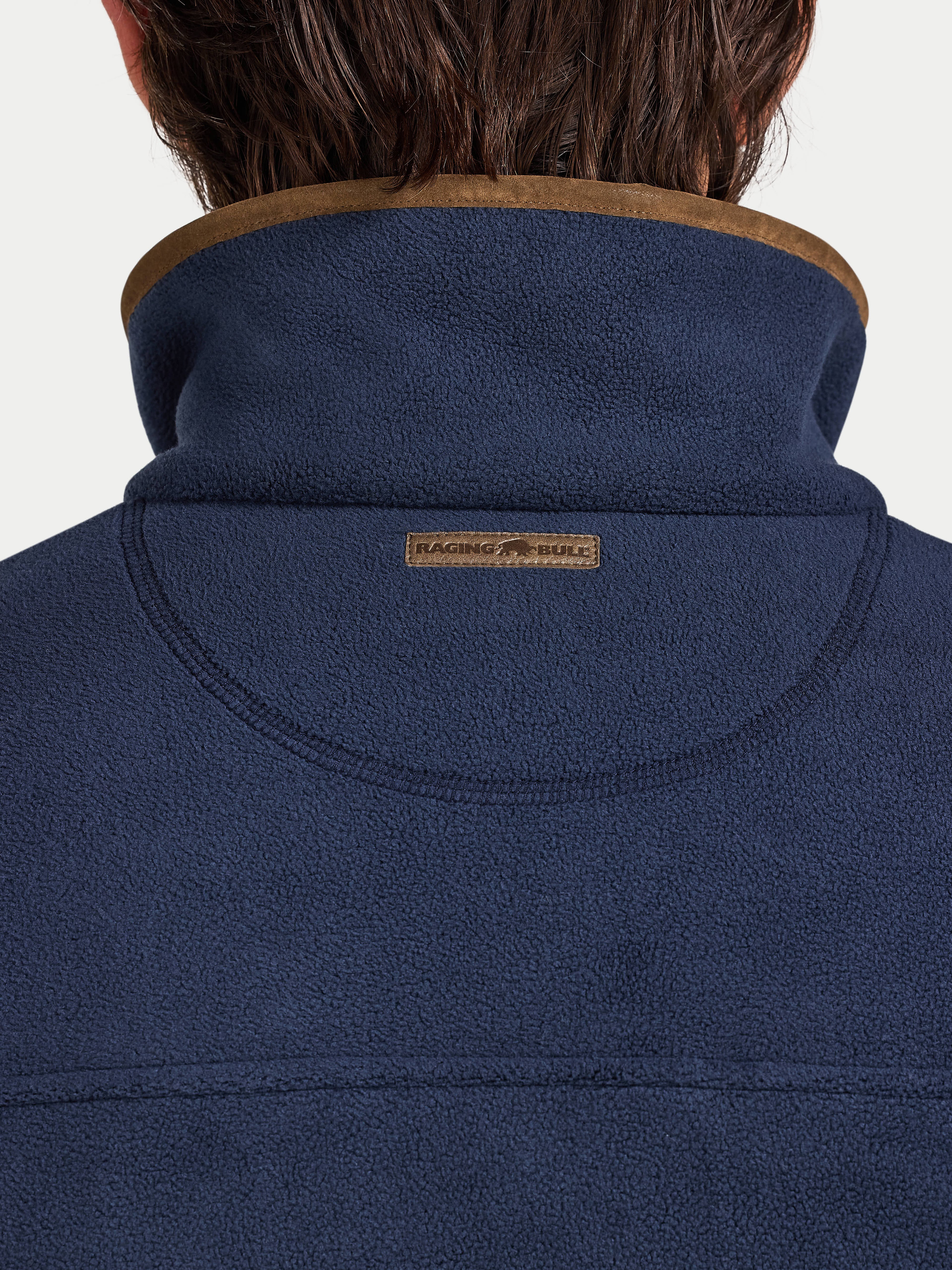 Navy blue jacket with brown collar and 'Raging Bull' logo on a white background