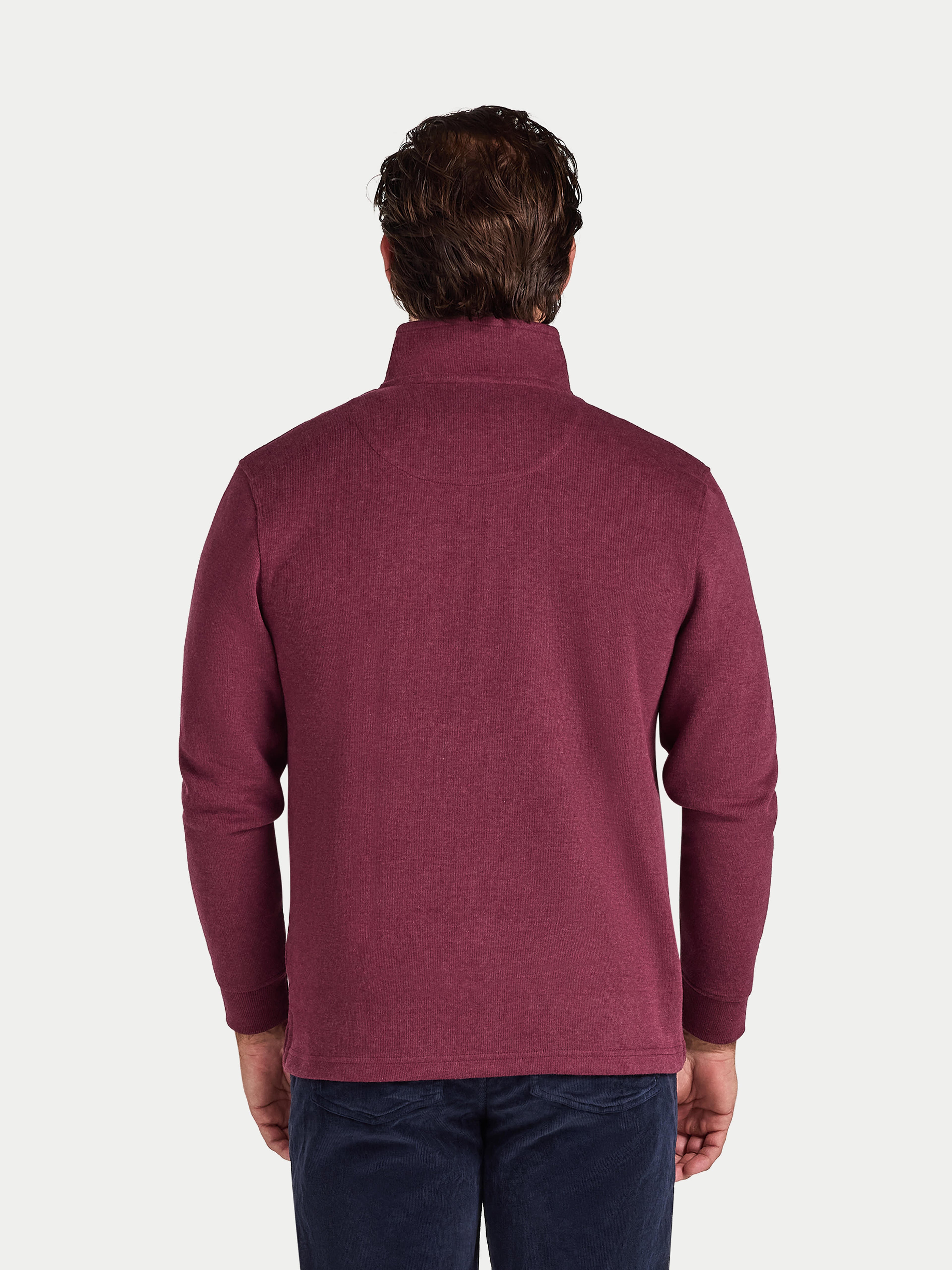 Man wearing a maroon fleece pullover on a white background