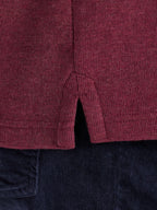 Close-up of a maroon textured fabric with a dark background
