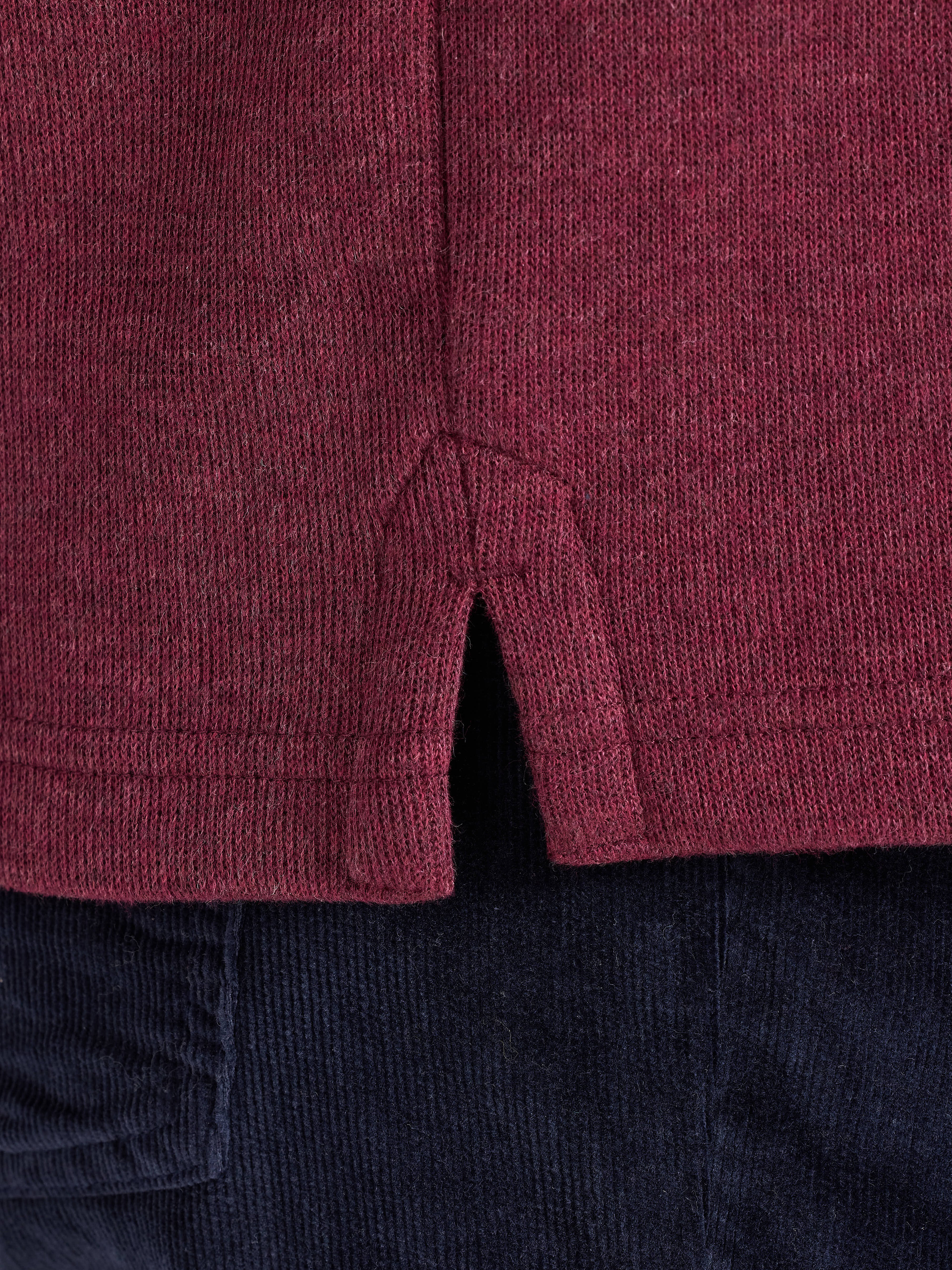 Close-up of a maroon textured fabric with a dark background