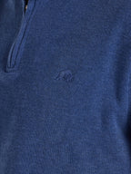Close-up of a blue sweater with a brand logo on a dark background