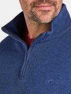Close-up of a person wearing a blue half-zip sweatshirt with a brand logo on a white background