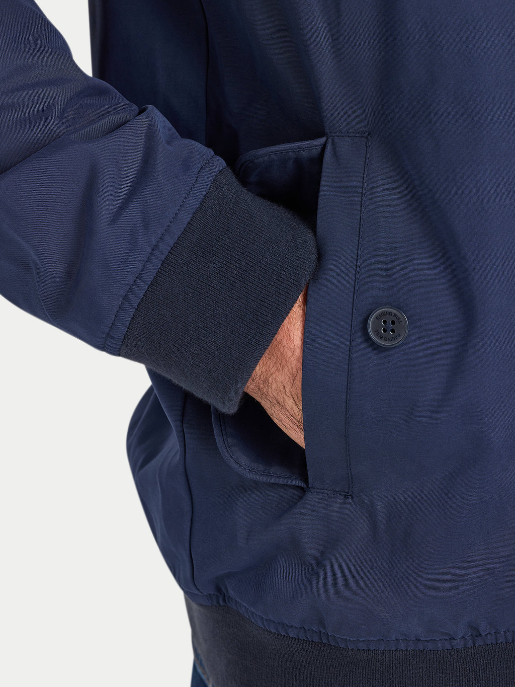 Close-up of a navy blue jacket with a button on a white background